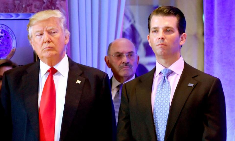 Allen Weisselberg stands behind Donald Trump and his son Don Jr.