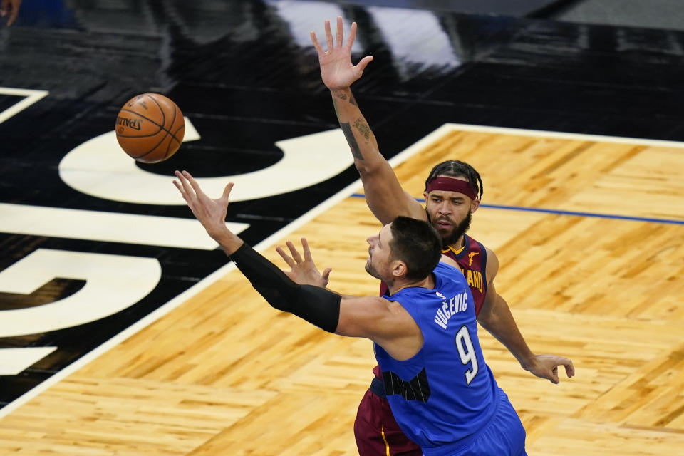 Orlando Magic center Nikola Vucevic (9) goes up for a shot against Cleveland Cavaliers center JaVale McGee, right, during the first half of an NBA basketball game, Wednesday, Jan. 6, 2021, in Orlando, Fla. (AP Photo/John Raoux)