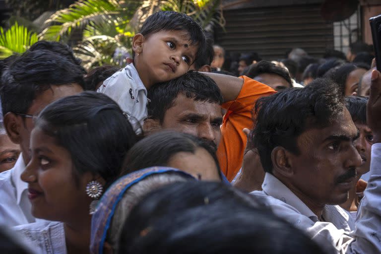 La gente se une mientras un vehículo que transporta una urna que se cree que contiene las cenizas sagradas de Buda es llevado en procesión en Mumbai, India, el miércoles 15 de febrero de 2023.