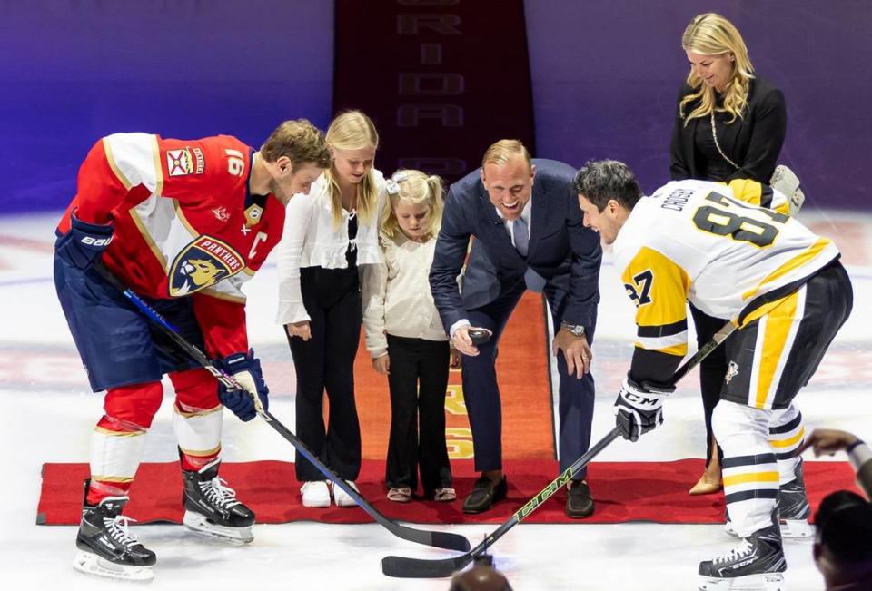 Former Florida Panthers player Patric Hornqvist, center, drops a ceremonial puck with Florida Panthers center Aleksander Barkov (16) and Pittsburgh Penguins center Sidney Crosby (87) before an NHL hockey game at the Amerant Bank Arena on Friday, Dec. 8, 2023, in Sunrise, Fla.