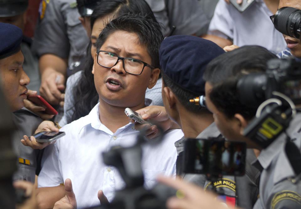 Reuters journalist Wa Lone, center, talks to journalists during he is escorted by polices as they leave the court Monday, Sept. 3, 2018, in Yangon, Myanmar. A Myanmar court sentenced two Reuters journalists, Wa Lone and Kyaw Soe Oo, to seven years in prison Monday for illegal possession of official documents, a ruling that comes as international criticism mounts over the military's alleged human rights abuses against Rohingya Muslims. (AP Photo/Thein Zaw)