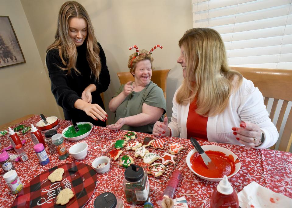 Leslie Larkins (center) laughs as she was frosting and putting sprinkles on Christmas cookies with her cousin Alexis Newcomer and her guardian Anne Newcomer this past December.