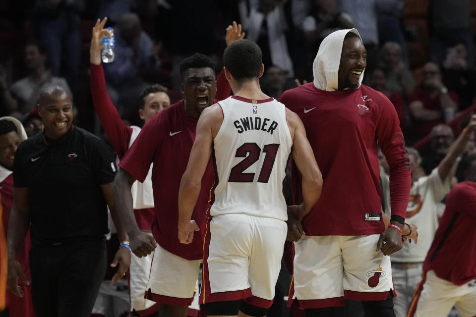 The Miami Heat cheer their teammates during the second half of an NBA preseason basketball game against the Charlotte Hornets, Tuesday, Oct. 10, 2023, in Miami. The Heat defeated the Hornets 113-109. (AP Photo/Marta Lavandier)