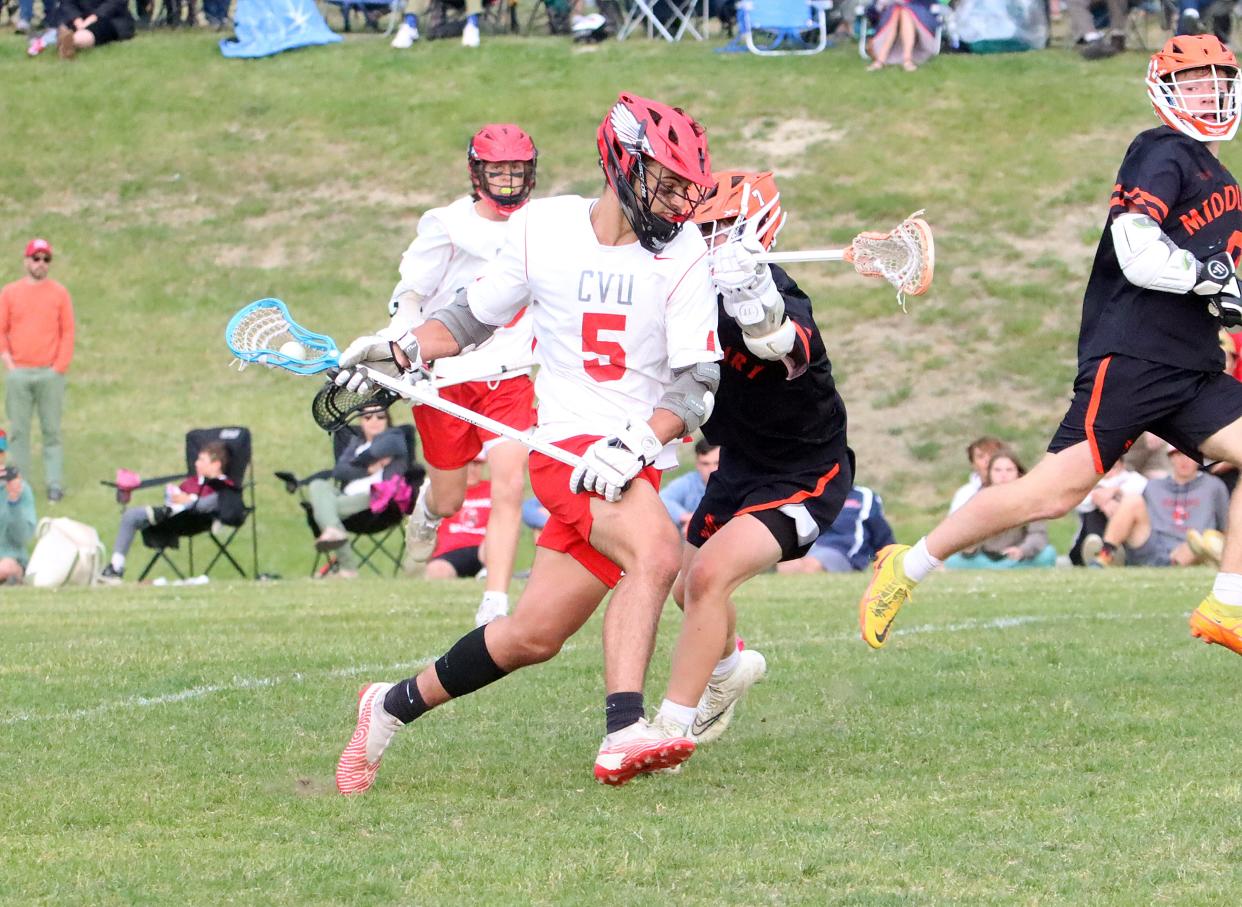 CVU's Jacob Bose slashes to the net during the Redhawks 9-5 loss to Middlebury in the 2023 D1 semifinals.