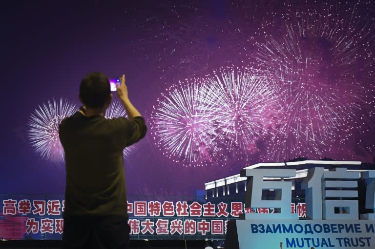A man uses his mobile phone to take a picture during the fireworks show at the Shanghai Cooperation Organisation summit