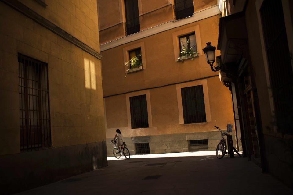 <p>Eine Frau im spanischen Madrid fährt mit dem Fahrrad die El-Codo-Straße entlang. (Bild: Francisco Seco/AP/dpa) </p>