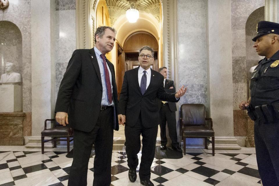 Sen. Sherrod Brown, D-Ohio, left, and Sen. Al Franken, D-Minn., leave the chamber during the vote on restoring jobless benefits for the long-term unemployed, legislation that expired late last year, at the Capitol in Washington, Monday, April 7, 2014. With their 17-day spring break beckoning at the end of the week, House and Senate lawmakers will have to scramble to reach agreement. (AP Photo/J. Scott Applewhite)