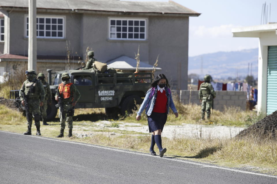 A student walks past a checkpoint outside the Almoloya prison where Ovidio Guzman, the son of imprisoned drug lord Joaquin “El Chapo” Guzman, is being held in Villa de Almoloya de Juarez, Mexico, Friday, Jan. 6, 2023. (AP Photo/Ginnette Riquelme)