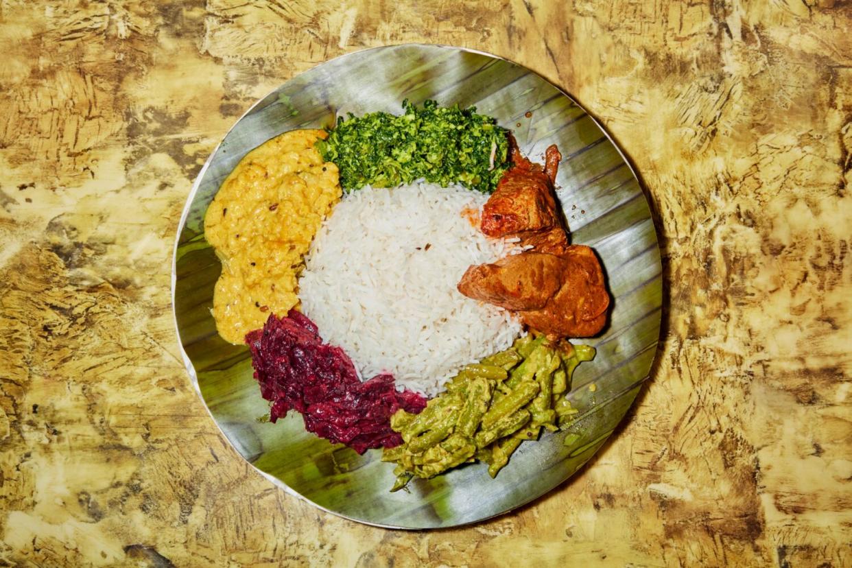 A colorful plate of fish curry served in a banana leaf