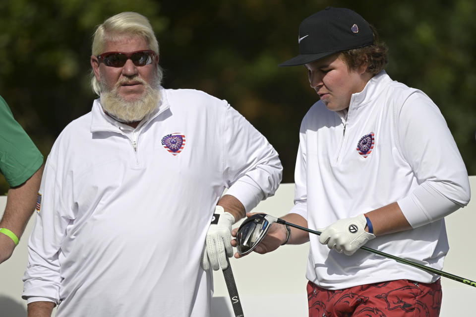 John Daly, left, watches as his son Little John Daly prepares to tee off on the first hole during the first round of the PNC Championship golf tournament, Saturday, Dec. 19, 2020, in Orlando, Fla. (AP Photo/Phelan M. Ebenhack)