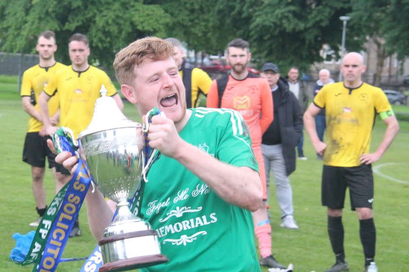 Skipper Ciaran McElroy holds aloft the trophy.