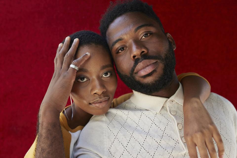 close up portrait of young man and woman against red wall