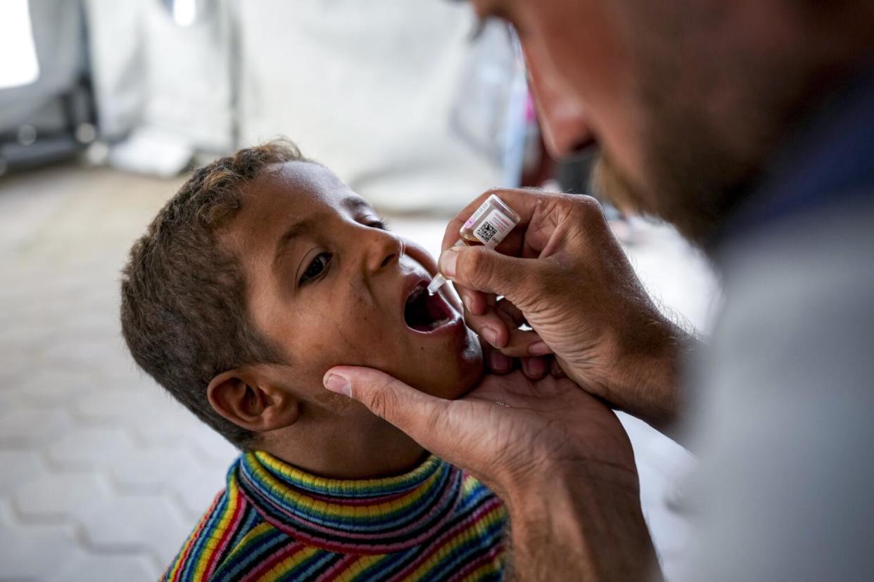 A health worker administers a polio vaccine to a child at a hospital in Deir al-Balah, central Gaza Strip,