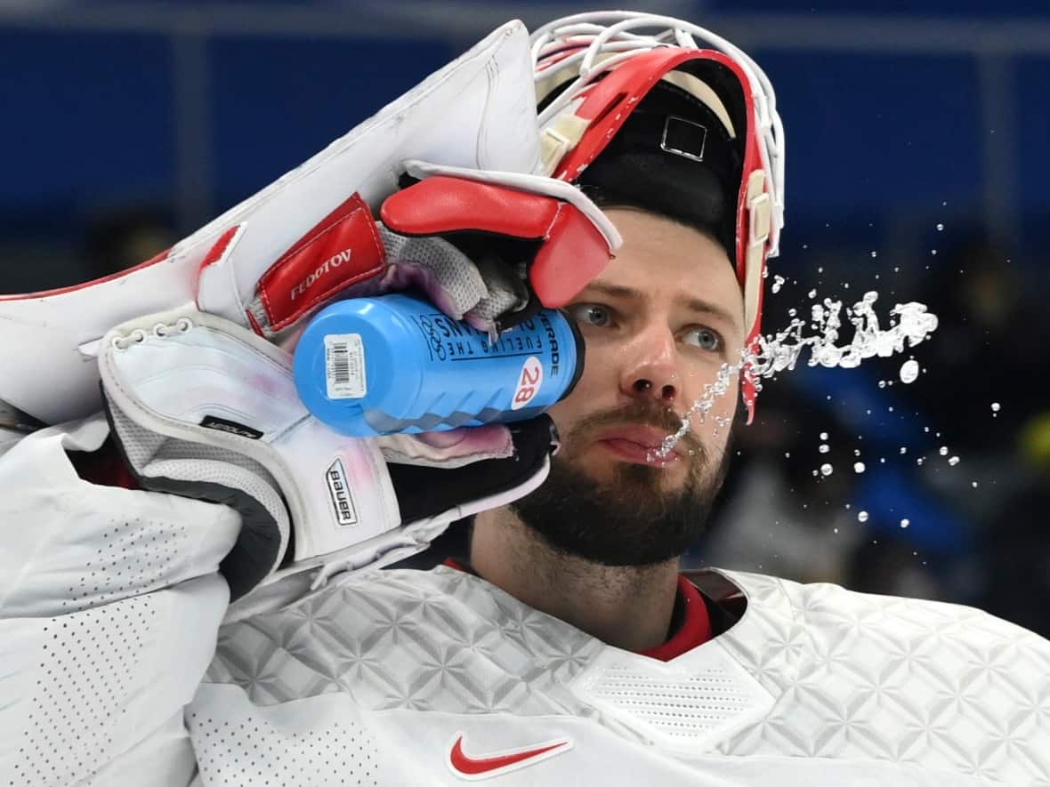 Ivan Fedotov, seen here in the gold medal game between Finland and the Russian Olympic Committee at the Winter Games in Beijing on Feb. 20, was detained in July and is accused of trying to dodge military conscription in Russia.  (Annegret Hilse/Reuters - image credit)