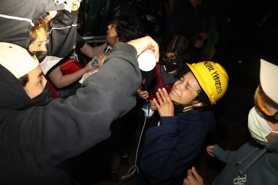 A person pours milk into the eyes of another.