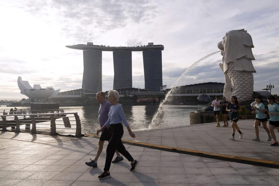 People exercise by the Merlion Park and Marina Bay Sands in Singapore, on Saturday, Oct. 8, 2022. Photographer: Ore Huiying/Bloomberg