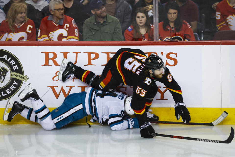 San Jose Sharks forward Alexander Barabanov, left, is checked by Calgary Flames defenseman Noah Hanifin during the second period of an NHL hockey game in Calgary, Alberta, Saturday, March 25, 2023.(Jeff McIntosh/The Canadian Press via AP)