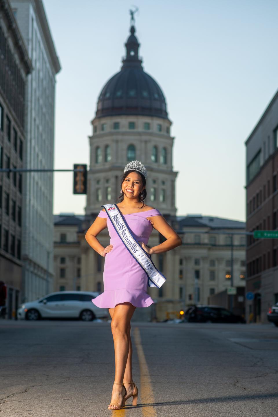 Seaman High School junior Madison Wabaunsee poses with her National All-American Miss Jr. Teen tiara and sash in the middle of S.E. 9th Street on Friday in downtown Topeka.