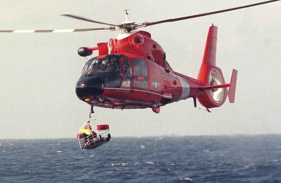 FILE - Balloonist Steve Fossett is retrieved by a U.S. Coast Guard helicopter from waters 10-15 miles north of the island of Oahu in the Hawaiian Islands, Dec. 25, 1998, after abandoning his quest along with Per Lindstrand, of Sweden, and British mogul Richard Branson, who were attempting to make the first nonstop round-the-world flight in a balloon. The massive hunt for the Titan submersible that imploded deep in the North Atlantic has refocused attention on whether wealthy risktakers should pay for emergency search and rescue efforts. (Richard Ambo/Honolulu Star-Advertiser via AP, File)