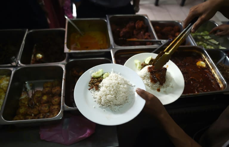 An assistant serves nasi lemak for waiting customers at the "Nasi Lemak Tanglin" stall in Kuala Lumpur