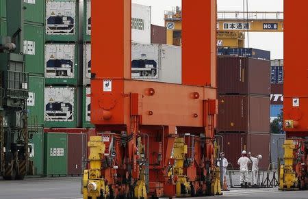 Workers are seen in a container area at a port in Tokyo September 18, 2014. REUTERS/Toru Hanai