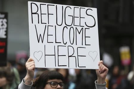 A demonstrator holds a placard during a refugees welcome march in London, Britain March 19, 2016. REUTERS/Neil Hall - RTSB7KT