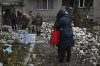 Local residents react near the destroyed house after recent Russian air strike in Chasiv Yar, Ukraine, Sunday, Nov. 27, 2022. Shelling by Russian forces struck several areas in eastern and southern Ukraine overnight as utility crews continued a scramble to restore power, water and heating following widespread strikes in recent weeks, officials said Sunday. (AP Photo/Andriy Andriyenko)