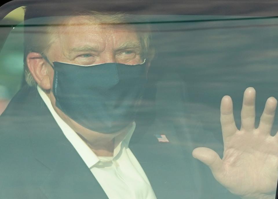 A car with US President Trump drives past supporters in a motorcade outside of Walter Reed Medical Center in Bethesda, Maryland on October 4, 2020 (AFP via Getty Images)