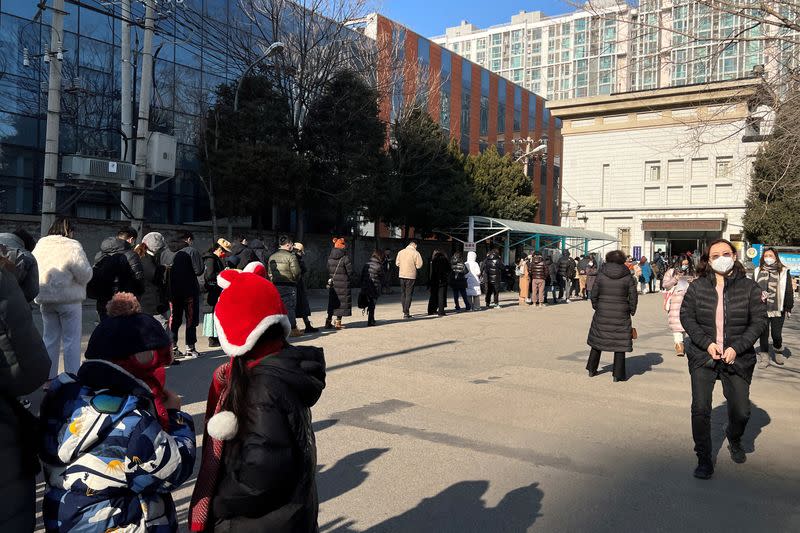 People line up at a government office after China reopened borders, in Beijing