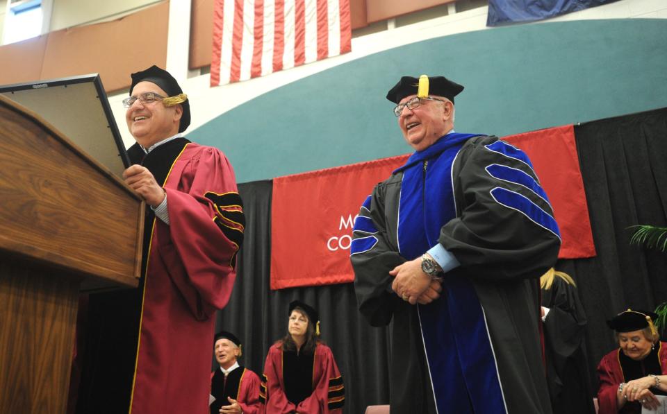 Monroe County Community College President David Nixon smiles as Board of Trustees Chairman Bill Bacarella Jr. jokes before reading the proclamation conferring upon him president emeritus status during the 2013 commencement ceremony in the Welch Health Education Building.