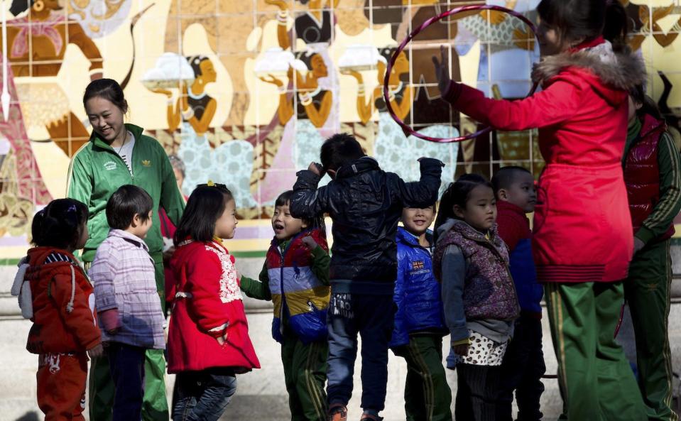 Varied approaches to teaching need not be treated as opposed to each other. Kindergarten teachers and children outdoors at the Ritan Park in Beijing in 2012. (AP Photo/Andy Wong)