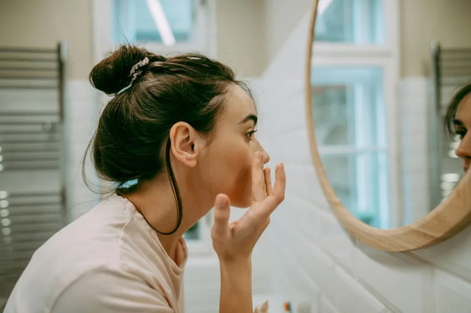 mujer joven mirándose al espejo