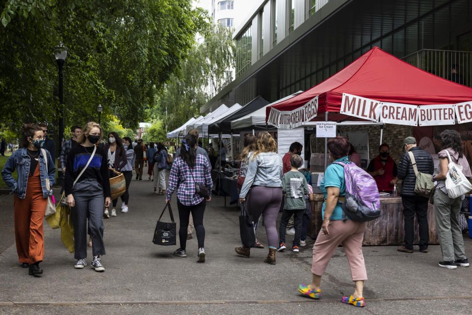 People shop at a crowded Saturday farmers market as business opens up with many people getting vaccinated in Portland, Ore., on Saturday, June 5, 2021. Until a year ago, the city was best known nationally for its ambrosial food scene, craft breweries and “Portlandia” hipsters. Now, months-long protests following the killing of George Floyd, a surge in deadly gun violence, and an increasingly visible homeless population have many questioning whether Oregon’s largest city can recover. (AP Photo/Paula Bronstein)