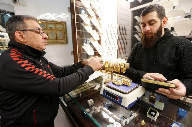 A customer looks at gold bracelets inside a jewellery shop in Beirut