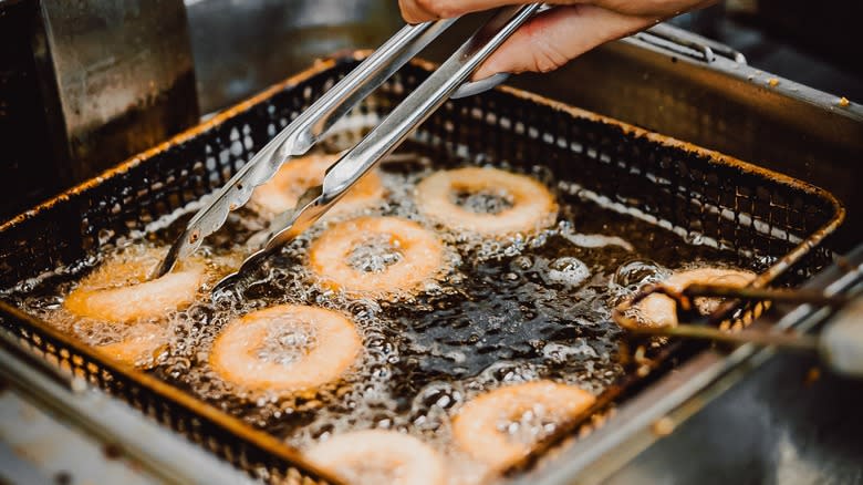 person frying onion rings