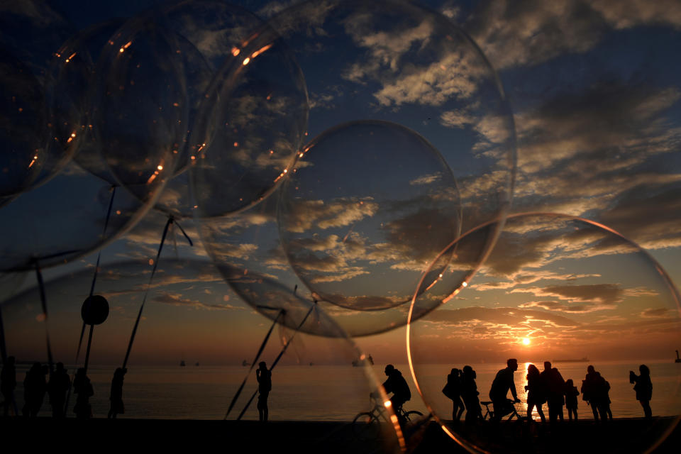 <p>An einer Strandpromenade in Thessaloniki, Griechenland, lassen transparente Ballons das Licht der untergehenden Sonne durchscheinen. (Bild: REUTERS/Alexandros Avramidis) </p>