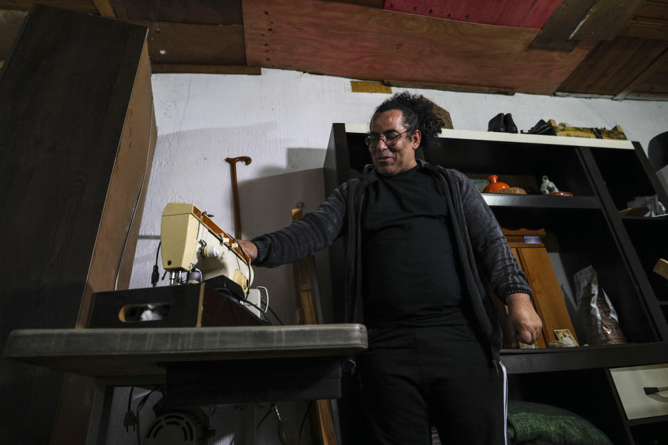 Luiz Cezar Pereira shows his late mother's sewing machine at his family's home in Guarulhos, Brazil, Friday, Oct. 1, 2021. Pereira's mother died of COVID-19 and was treated by health care company Prevent Senior, which is under investigation for allegedly forcing doctors to test unproven drugs on coronavirus patients. Pereira's mother was treated with flutamide, a drug typically used for prostate cancer, for which he eventually consented after resisting when his online research found it wasn’t scientifically proven. (AP Photo/Marcelo Chello)