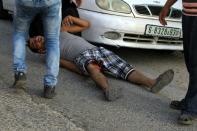 A Palestinian demonstrator lays on his back after being reportedly shot in the leg by Israeli soldiers in a street, east of the West Bank city of Nablus, on October 3, 2015