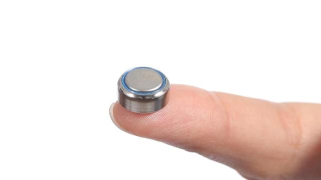 Woman hand holding a button battery with the forefinger