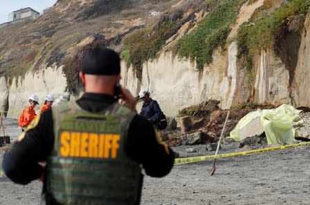 Emergency responders attend to a cliff collapse at a beach in Encinitas, California