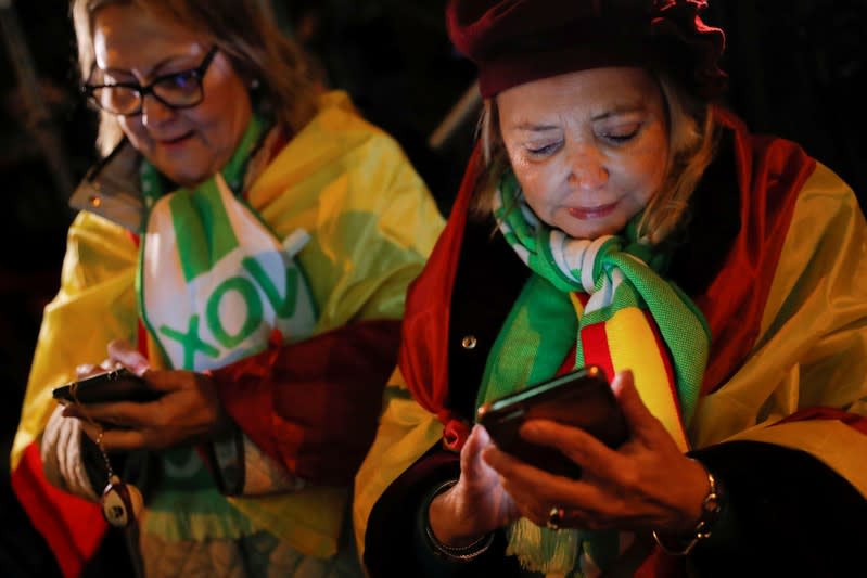 Supporters of Spain's far-right party VOX use their mobile phones to follow results in Spain’s general election in Madrid