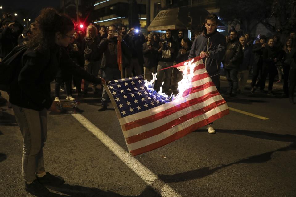 Protesters burn an American flag outside the US Embassy during a rally in Athens, Saturday, Nov. 17, 2018. Several thousands people march to the U.S. Embassy in Athens under tight police security to commemorate a 1973 student uprising that was crushed by Greece's military junta, that ruled the country from 1967-74. (AP Photo/Yorgos Karahalis)
