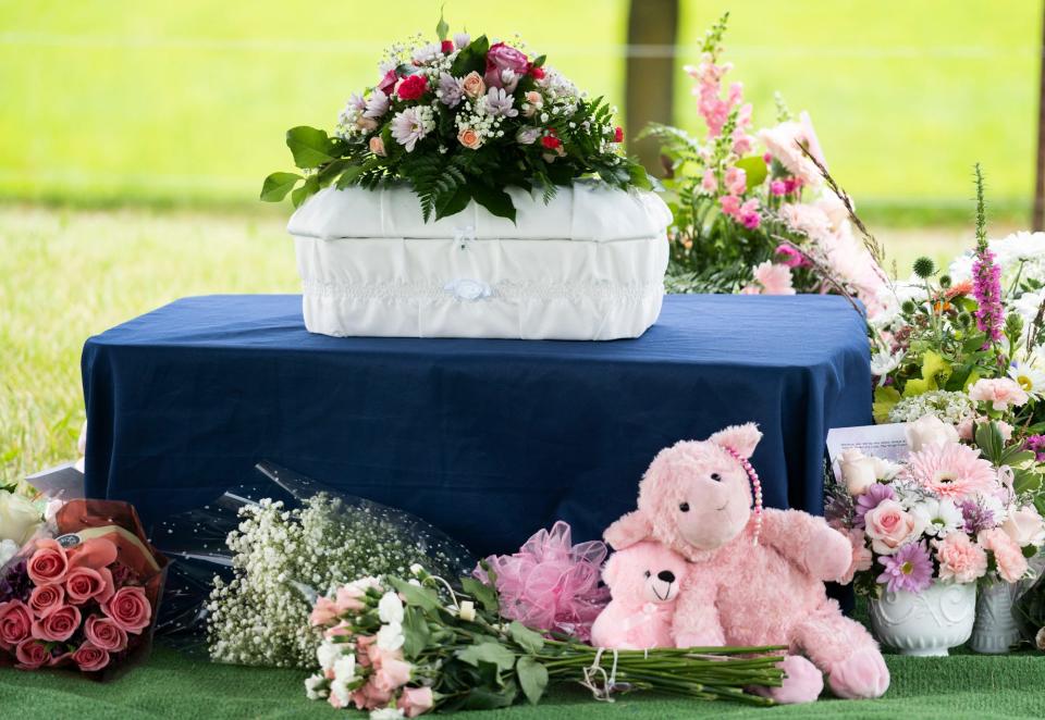 Stuffed animals and flowers still decorate the headstone of Madison Baby Doe," an unidentified infant whose body was found in the trash in Plain City on June 15th. This file photo shows her casket bedecked by stuffed animals and flowers during burial services on June 24.