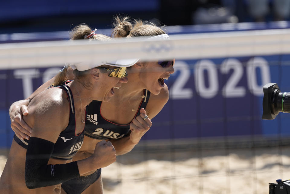 April Ross, left, of the United States, and teammate Alix Klineman celebrate winning a women's beach volleyball semifinal match against Switzerland at the 2020 Summer Olympics, Thursday, Aug. 5, 2021, in Tokyo, Japan. (AP Photo/Petros Giannakouris)