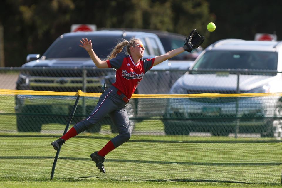 Crestwood freshman centerfielder Alyssa Hallis dives into the outfield fence while attempting to make a catch during Tuesday’s sectional tournament game against Gilmour Academy at Crestwood High School.