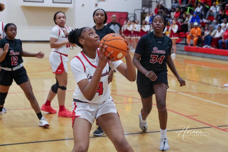 Hardaway High School girls basketball team members, wearing white uniforms, Akilah Shelton (with the ball) and Adazha Burrell play in a game during the 2023-24 season.