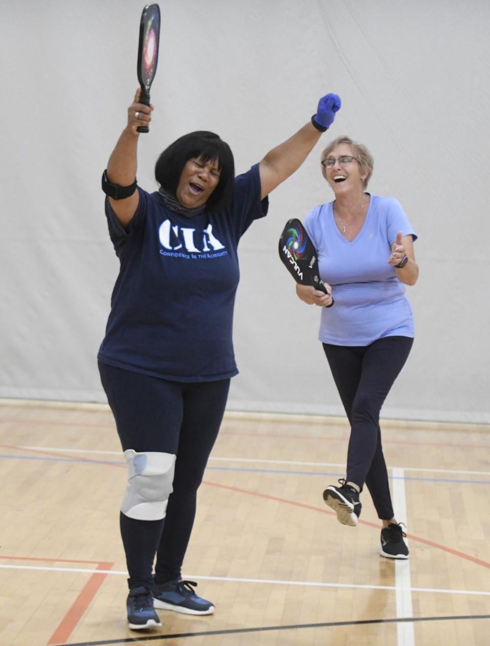Karen Rudolph, left, and her pickleball partner, Kathy Harper, celebrate scoring a point, while playing pickleball at the Massillon Recreation Center in this file photo from 2020.