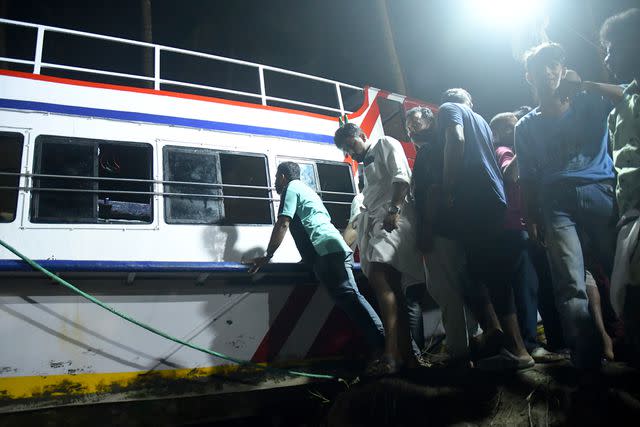 P.P. Afthab/AP Photo Rescuers gather after pulling tourist boat to shore