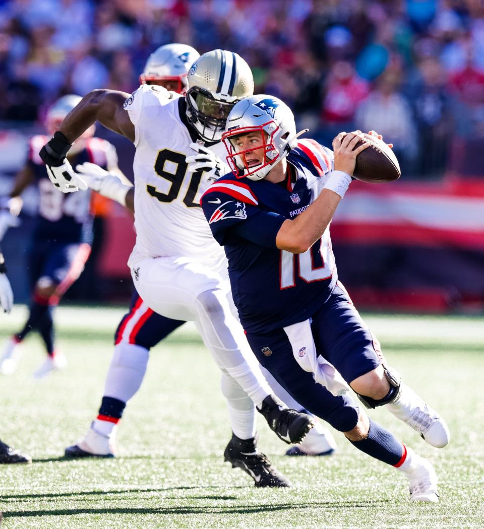 New England Patriots quarterback Mac Jones  scrambles from New Orleans Saints defenders on Sept. 26.