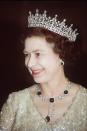 <p>Here, Queen Elizabeth is wearing the Girls Of Great Britain and Ireland diamond tiara and the Cambridge and Delhi Durbar parure—an emerald-and-diamond set of earrings and a necklace that she inherited from her grandmother Queen Mary.</p>